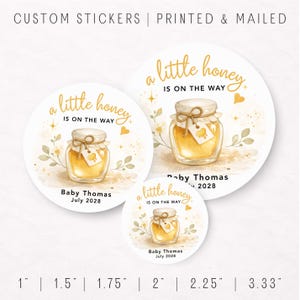 May include: Round stickers with a watercolor illustration of a honey jar, text reads "a little honey is on the way." The stickers are in various sizes, with the name "Baby Thomas" and the date "July 2028" printed on them.