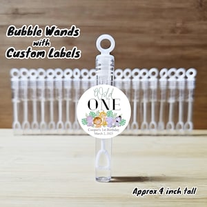 May include: A set of clear plastic bubble wands with a white round sticker that says "Wild One" with a jungle animal theme. The sticker also includes the text "Cooper's 1st Birthday March 2, 2025". The wands are approximately 4 inches tall.
