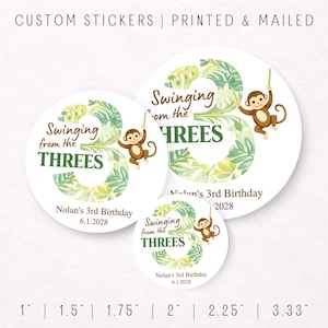 May include: White round stickers with a jungle theme. The stickers feature a large number 3 with green leaves, a brown monkey, and the text "Swinging from the THREES". The stickers are for a 3rd birthday.