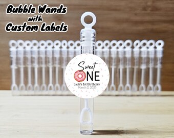 May include: A set of clear plastic bubble wands with a donut-themed label that says "Sweet One" with a pink and white donut graphic. The label also includes the text "Jada's 1st Birthday March 2, 2025". The wands are approximately 4 inches tall.
