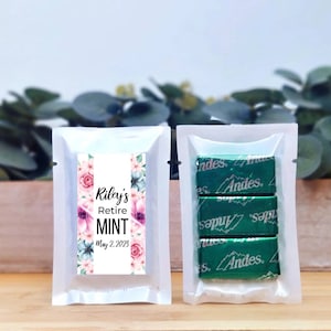 May include: A white favor bag with a floral design and the text "Riley's Retire MINT May 2, 2023". The bag contains three individually wrapped Andes mints.