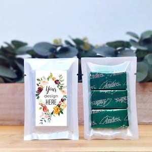 May include: Two clear plastic pouches, one with a floral design and the text "Your design HERE" and the other with three individually wrapped Andes mints.