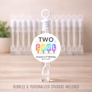 May include: Clear bubble wands with a white label that reads "TWO COOL" with colorful popsicle graphics. The label also includes the text "Grayson's 2nd Birthday April 4, 2027". The image includes the text "BUBBLES & PERSONALIZED STICKERS INCLUDED".