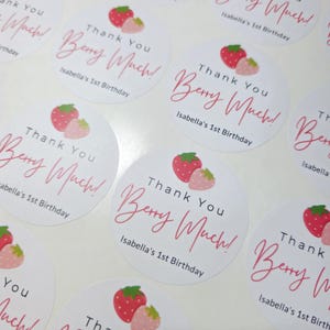 Może przedstawiać: Okrągłe białe naklejki z wzorem r&oacute;żowej truskawki i tekstem "Thank You Berry Much!" i "Isabella's 1st Birthday".