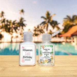 May include: Two clear plastic bottles with flip-top lids. The bottles have labels with jungle animal designs and text that reads "Thank you for celebrating with us! Carson's 1st Birthday SPF 25" and "Rihanna's 1st Birthday 9.29.2023".