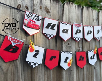 May include: A red, white, and black Cars themed birthday banner with the words "Happy Birthday" and a red race car with flames.