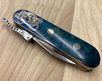 Składany nóż SAK 91 mm z jednym rzędem ostrzy w stylu steampunk, otwierany jedną ręką, z ostrzami Elmax HRC61. Tytan, mosiądz, drewniane elementy zegarka.