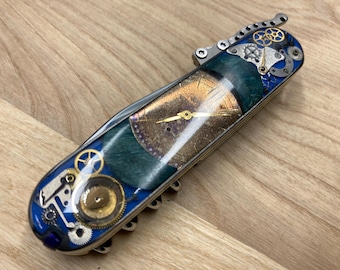 Składany nóż SAK 91 mm z jednym rzędem ostrzy w stylu steampunk, otwierany jedną ręką, z ostrzami Elmax HRC61. Tytan, mosiądz, drewniane elementy zegarka.