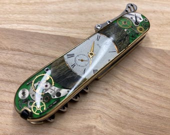 Składany nóż SAK 91 mm z jednym rzędem ostrzy w stylu steampunk, otwierany jedną ręką, z ostrzami Elmax HRC61. Tytan, mosiądz, drewniane elementy zegarka.