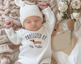 Babyrompertje/rompertje cadeau voor pasgeborenen Teckel Beschermd door... Gepersonaliseerd naamcadeau voor hondenliefhebbers met een baby