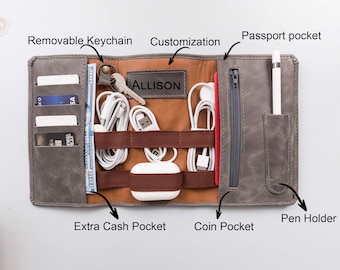 Könnte beinhalten: Grauer Leder-Reiseorganizer mit mehreren Taschen und Fächern. Zu den Merkmalen gehören ein abnehmbarer Schlüsselanhänger, eine Reisepasstasche, ein Stifthalter und eine zusätzliche Bargeldtasche. Der Innenraum ist braun mit dem geprägten Namen "ALLISON".