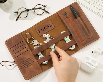 May include: A brown leather organizer roll featuring a zippered pocket, a pen slot, elastic straps for cables, and a key ring. The leather is embossed with the name LUCAS and the text: Distance means nothing when love is constant. I love you, Happy Father's Day, Dad!