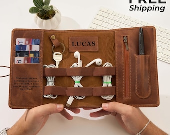 May include: A brown leather organizer featuring slots for credit cards, a key ring, elastic bands for white cables, a zippered pocket, and a pen holder. The interior is embossed with the name LUCAS and a quote about love and Father's Day.