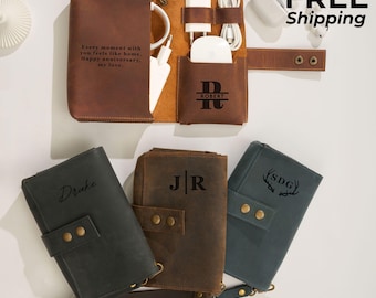 May include: Leather tech organizer in brown, black, and teal. The brown organizer is open, displaying charging cables and a white charging block. The text "Every moment with you feels like home. Happy anniversary, my love." is visible. Other organizers are closed, with initials or names.