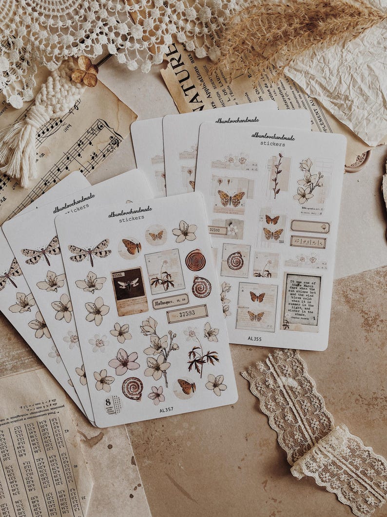 May include: Four sheets of stickers featuring illustrations of butterflies, flowers, and vintage-style text. The stickers are on a white background with a brown border. The text on the stickers reads "albanlovehandmade" and "stickers".