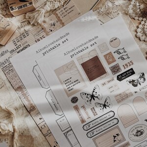 May include: A printable set of vintage-style stickers featuring butterflies, a journal, a stamp, and other decorative elements. The stickers are printed on white paper with a brown background.