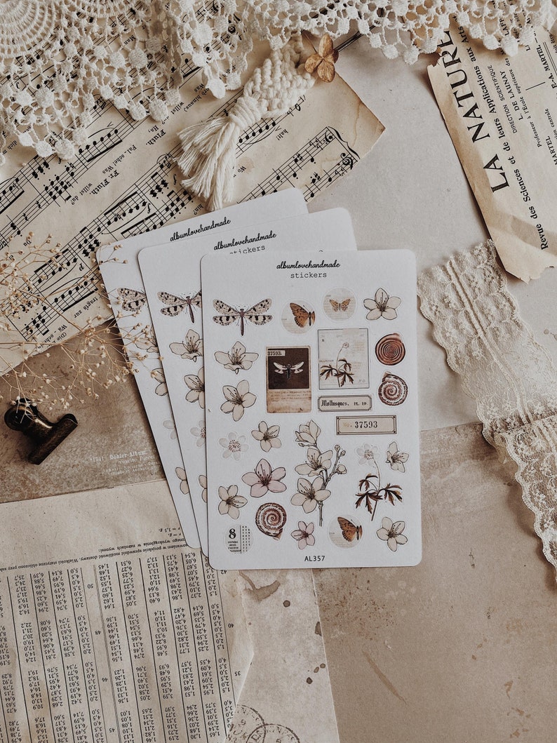 May include: A set of 8 floral and butterfly stickers with a vintage aesthetic. The stickers are printed on white paper and feature delicate illustrations of flowers, butterflies, and other nature-inspired designs. The stickers are perfect for adding a touch of whimsy to journals, planners, and other craft projects.
