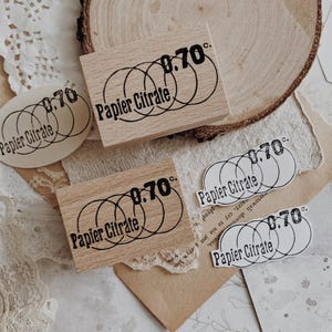 May include: Two rectangular wooden stamps and three paper cutouts featuring a black ink design of three overlapping circles, the text "Papier Citrate," and the number "0.70c." The stamps have a light wood grain finish and a rectangular shape.