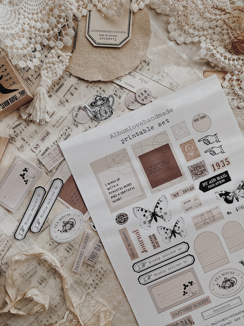 May include: A printable set of stickers featuring a variety of designs, including butterflies, teapots, and text. The stickers are in a vintage style with a brown and white color scheme. The text on the stickers includes phrases like "This Day", "Journal", and "Captured Moment".