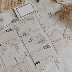 May include: A collection of vintage-style postcards with a map, stamps, and handwritten text. The postcards are in shades of beige and brown with a distressed look. The text on the postcards includes "Here We Are!" and "By Air Mail".