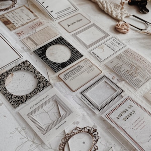 May include: A collection of adhesive stickers featuring vintage-style frames, labels, and text including A new idea, Eiseris, ITS A BEAUTIFUL DAY, HAPPY PLACE, HAVE A NICE DAY, LONDON ON WHEELS, and VERY SPECIAL, with various patterns and borders.