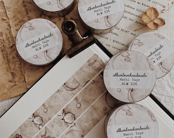 May include: Five rolls of brown washi tape with a coffee stain pattern. Each roll has a white label with the text "albumlovehandmade" and "Washi Tape" in black text. The text "ALW 326" is also on the label in black text.