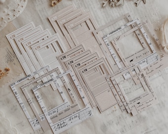 May include: A collection of vintage-style paper frames with a decorative border. The frames are in various sizes and shapes, and some have text printed on them, including "ICITE - PHONOGRAPHES" and "For førs".