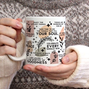 Puede incluir: Taza de cer&aacute;mica blanca con texto negro e ilustraciones. El texto dice "Disfruta de las cosas m&aacute;s peque&ntilde;as", "T&oacute;mate el tiempo para hacer las cosas que llenan tu alma", "Elige sentir la paz", "Celebra cada peque&ntilde;a victoria", "Siempre has sido suficiente", "Soy amado + Soy digno de bondad".