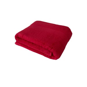 May include: A folded red bath towel. The towel is made of soft, absorbent material.