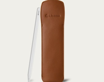 May include: A brown leather pencil case with the text "GLLSCOFONE" embossed on the front. A white Apple Pencil is standing next to the case.