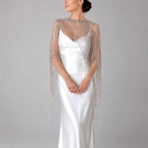 Silver sequin wrap worn over a wedding gown, creating a romantic and timeless bridal look.