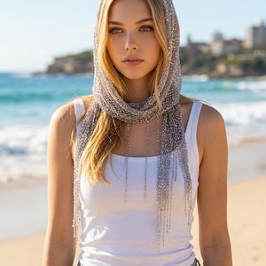 Silver sequin shawl worn as a headscarf, elegant beach accessory and lightweight scarf for summer vacations.