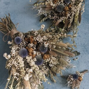 Puede incluir: Un conjunto de tres ramos de flores secas en tonos blancos, beige y azules. Los ramos est&aacute;n hechos con hierbas secas, flores y eucalipto.