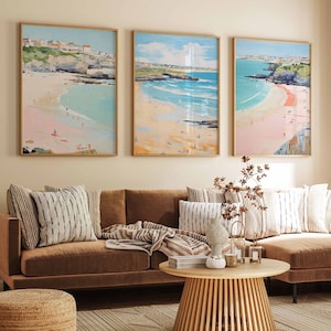 May include: A brown sectional sofa with three throw pillows, a throw blanket, and a wooden coffee table. Three framed paintings of seascapes hang on the wall behind the sofa.