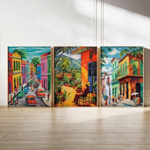 May include: Three colorful paintings depicting scenes of a vibrant city street with buildings, palm trees, and people. The paintings are framed in gold and hung on a white wall.