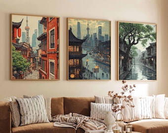 May include: Three framed prints of cityscapes. The first print shows a street scene in a city with tall buildings and a red pagoda. The second print shows a city with a river and a bridge. The third print shows a street scene with a large tree and a building with a pagoda roof.