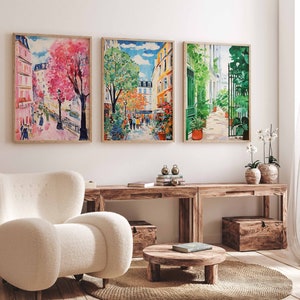 K&ouml;nnte beinhalten: Drei gerahmte Aquarelle, die Pariser Stra&szlig;enszenen darstellen. Das erste Bild zeigt einen rosa Baum in voller Bl&uuml;te, das zweite einen gr&uuml;nen Baum und das dritte einen gr&uuml;nen Torbogen mit einem Garten.