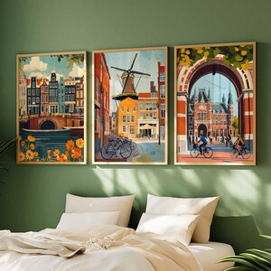 Pu&ograve; includere: Tre stampe artistiche incorniciate raffiguranti paesaggi urbani olandesi. L'opera presenta edifici colorati, canali, mulini a vento e ciclisti. Le stampe sono in cornici dorate e sono esposte su una parete verde sopra un letto con biancheria da letto bianca.