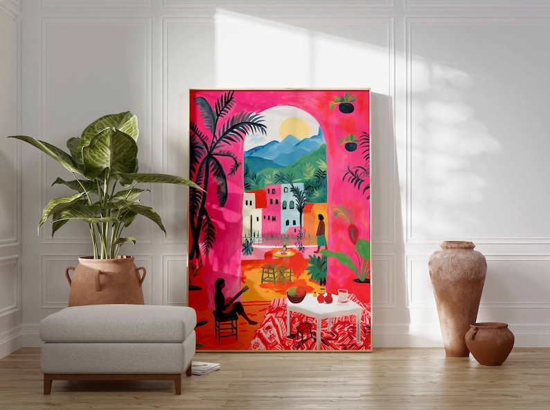 May include: A colorful painting depicting a scene of a tropical courtyard with a woman sitting on a chair and a woman walking away. The painting is framed and hanging on a white wall.