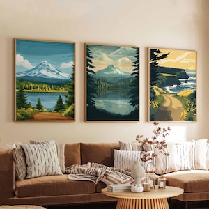 May include: Three framed landscape art prints. The prints depict mountain and lake scenes with a color palette of blues, greens, and yellows. The artwork is displayed above a brown sofa with decorative pillows.