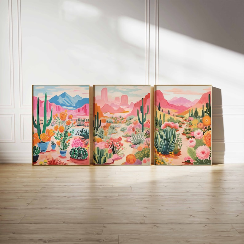 May include: Three framed prints of desert landscapes with cacti, flowers, and mountains in shades of pink, orange, and green.