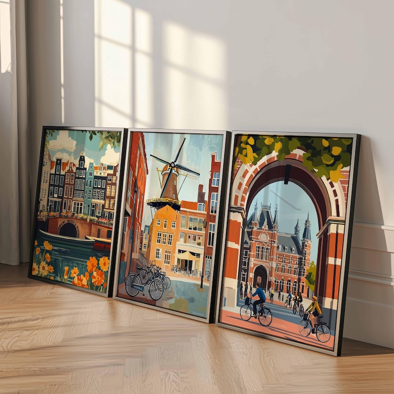 Pu&ograve; includere: Tre stampe artistiche incorniciate raffiguranti scene di Amsterdam. L'opera presenta edifici colorati, canali, un mulino a vento e ciclisti. Le stampe sono esposte su un pavimento in legno, appoggiate a una parete bianca e sono incorniciate in nero.