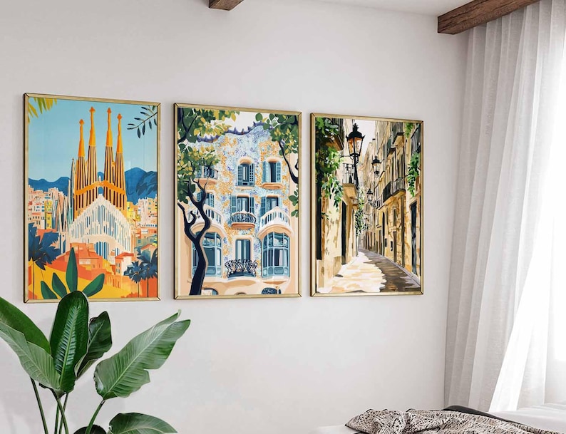 May include: Three framed art prints depicting European cityscapes. The artwork includes a colorful depiction of a cathedral, a building with blue and white details, and a narrow street with streetlights. The frames have a gold finish.