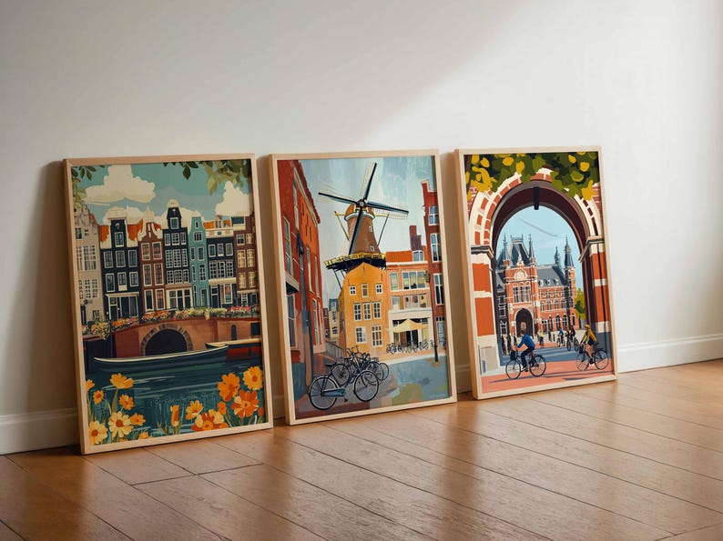 Pu&ograve; includere: Tre stampe artistiche incorniciate raffiguranti scene di Amsterdam. L'opera presenta edifici colorati, canali, mulini a vento e ciclisti. Le stampe sono esposte su un pavimento in legno contro un muro bianco, con un tema di viaggio.