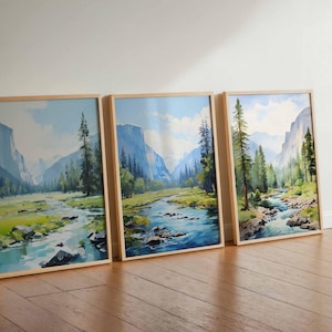 May include: Three framed landscape watercolor paintings featuring a river flowing through a valley with mountains and trees. The artwork has a natural wood frame and a serene, outdoorsy theme.