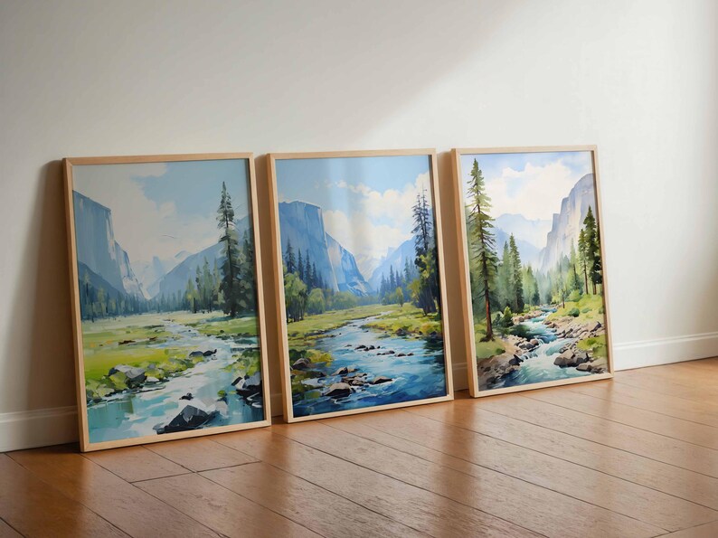 May include: Three framed landscape watercolor paintings featuring a river flowing through a valley with mountains and trees. The artwork has a natural wood frame and a serene, outdoorsy theme.