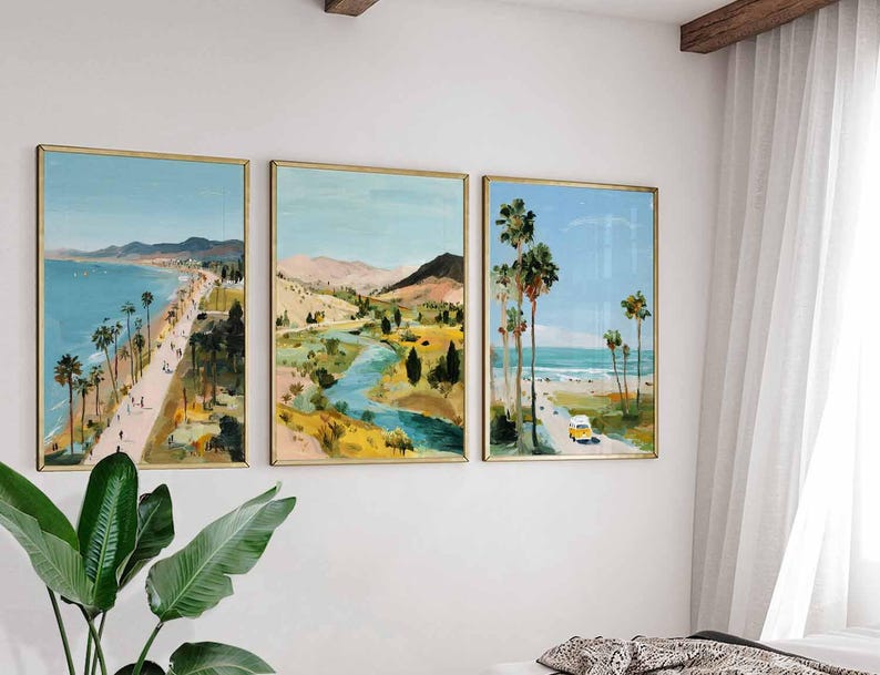 May include: Set of three framed landscape paintings. The artwork depicts coastal scenes with palm trees, beaches, and a yellow vehicle. The paintings have gold frames and are displayed on a white wall, creating a cohesive art collection.