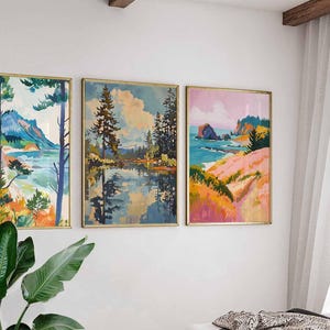 May include: Three framed landscape paintings with gold frames hang on a white wall. The paintings depict colorful scenes of nature, including mountains, lakes, and coastal views. The artwork features a variety of colors, including blues, greens, pinks, and oranges.