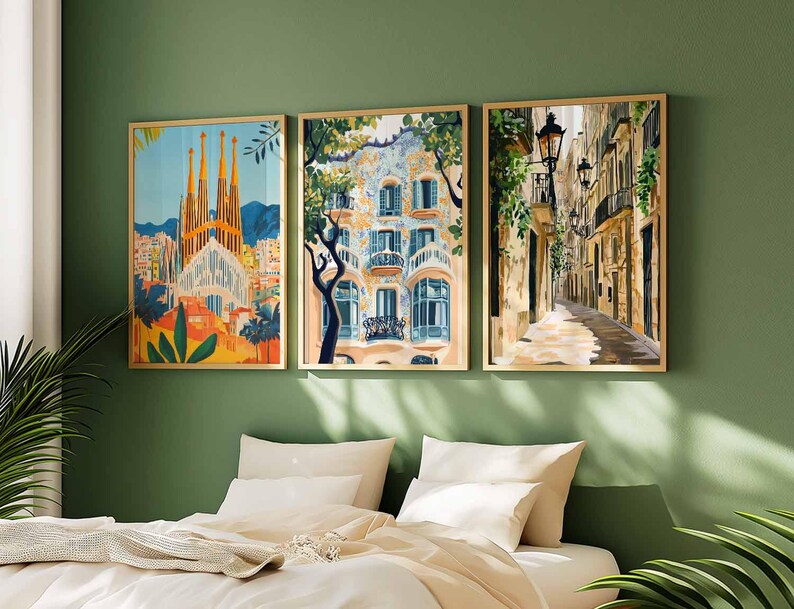 May include: Three framed art prints depicting architectural scenes. The prints feature a cathedral, a building with balconies, and a narrow street with streetlights. The frames are gold-colored, and the artwork is displayed on a green wall above a bed.