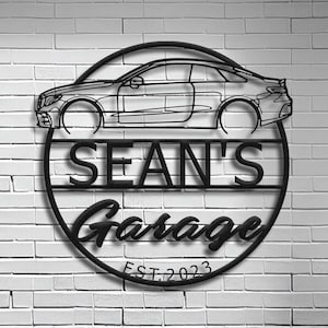 Puede incluir: Un letrero de metal negro con una silueta de un coche, el texto "SEAN'S Garage EST. 2023" y un borde decorativo.